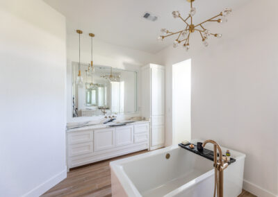 Elegant bathroom featuring a Bianca Lasa Macchia Vecchia 2cm Quartzite countertop on a white vanity with gold fixtures and a modern bathtub.