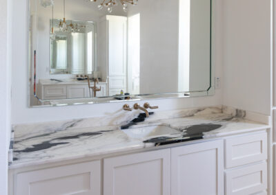 Elegant bathroom featuring a Bianca Lasa Macchia Vecchia 2cm Quartzite countertop on a white vanity with gold fixtures and a modern bathtub.